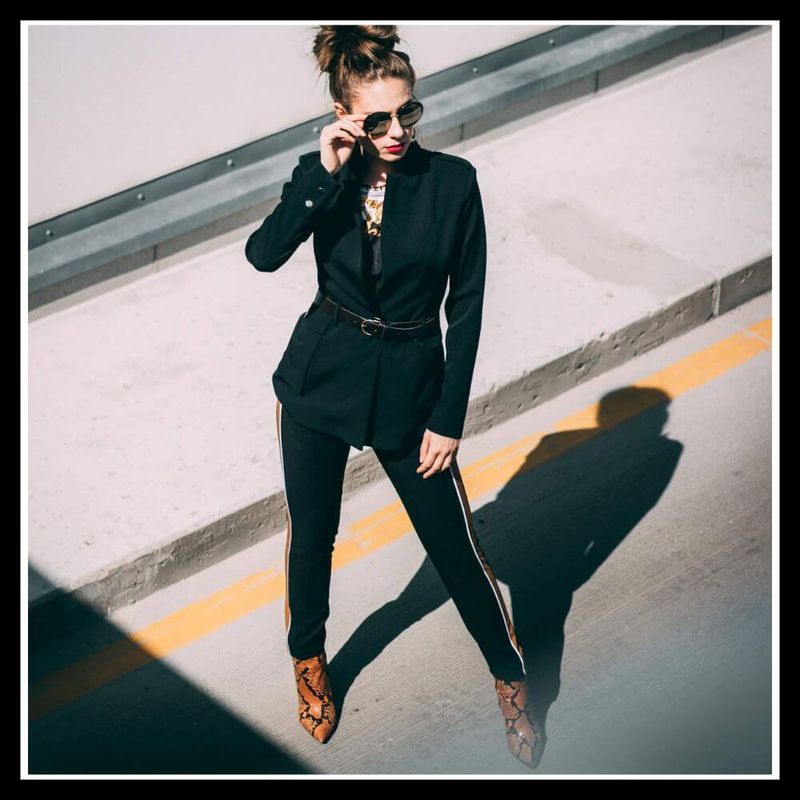 Stylish woman in black outfit and embossed boots