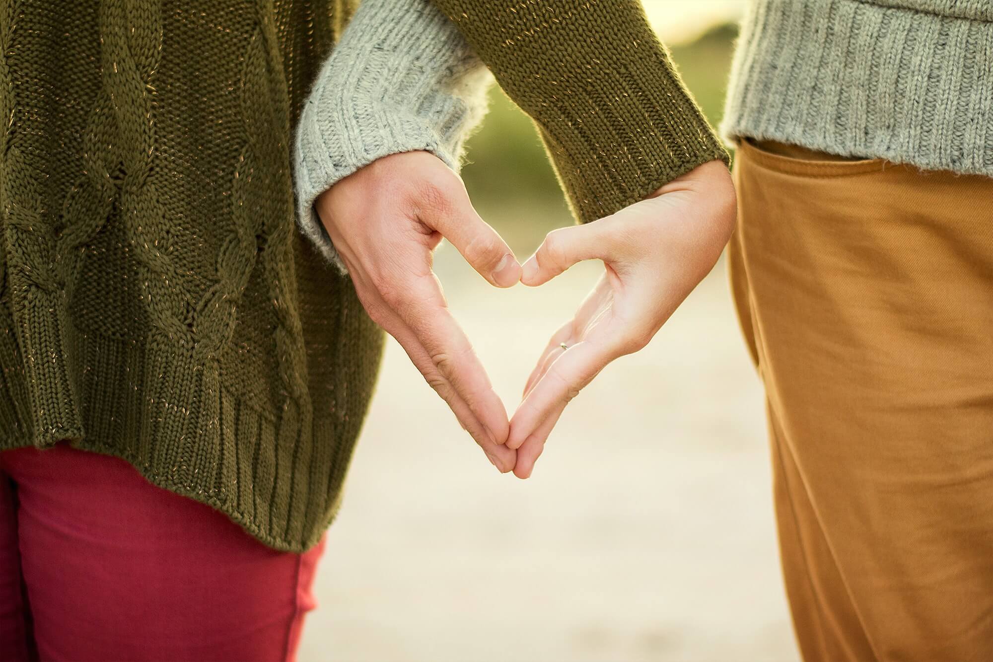 A couple wearing sweaters holding hands